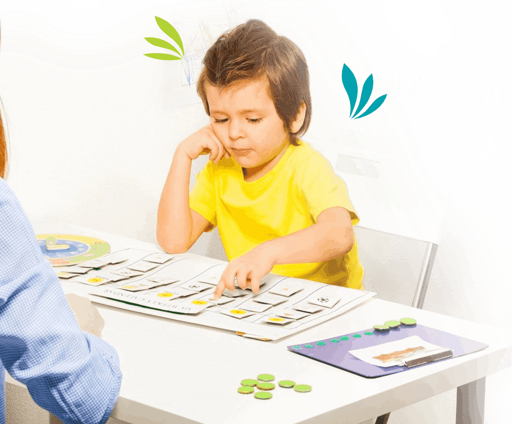 A young child engaged in play therapy activities at a table